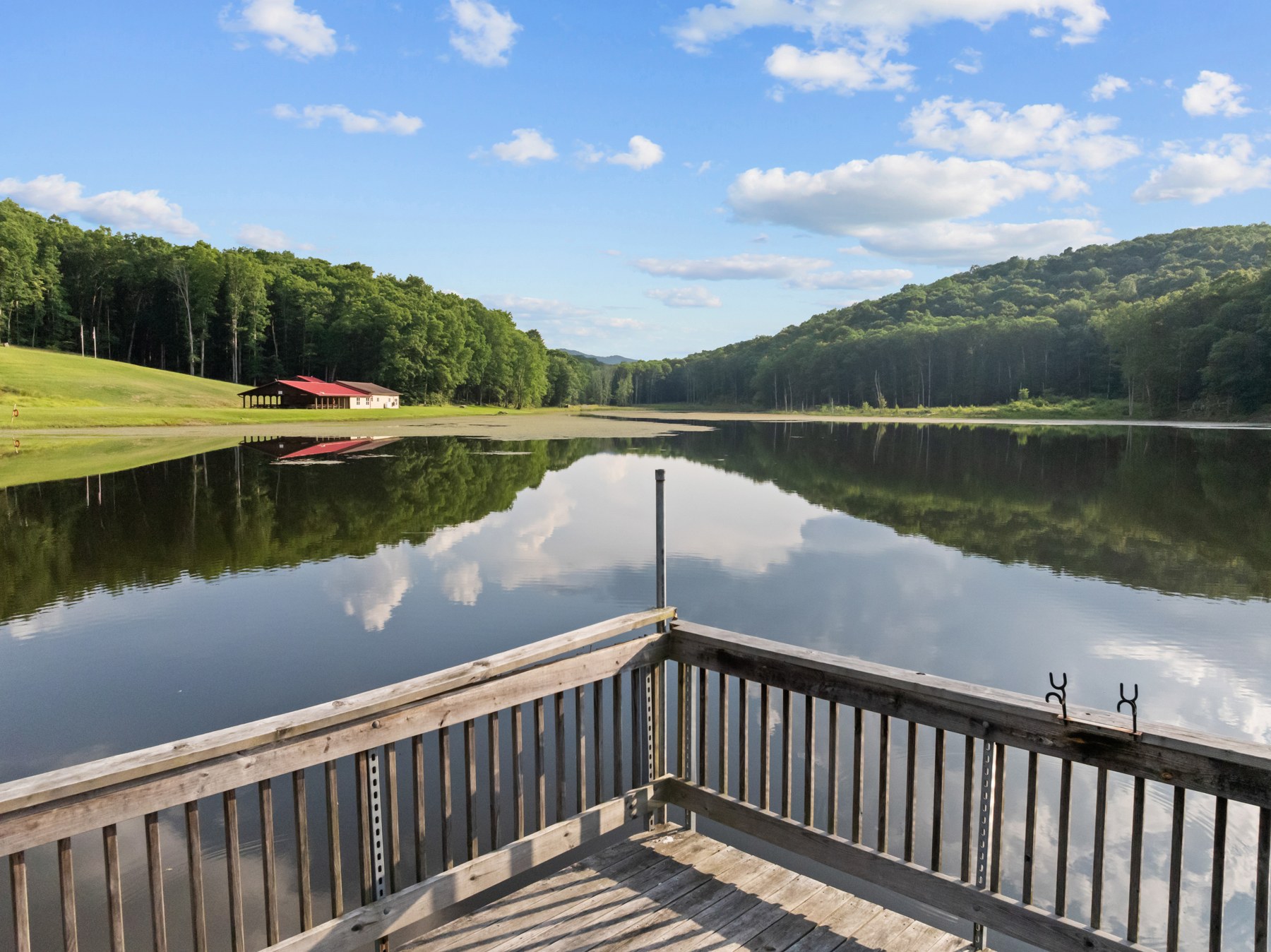 View from the dock across the private lake toward Lake Hall and the wooded valley
