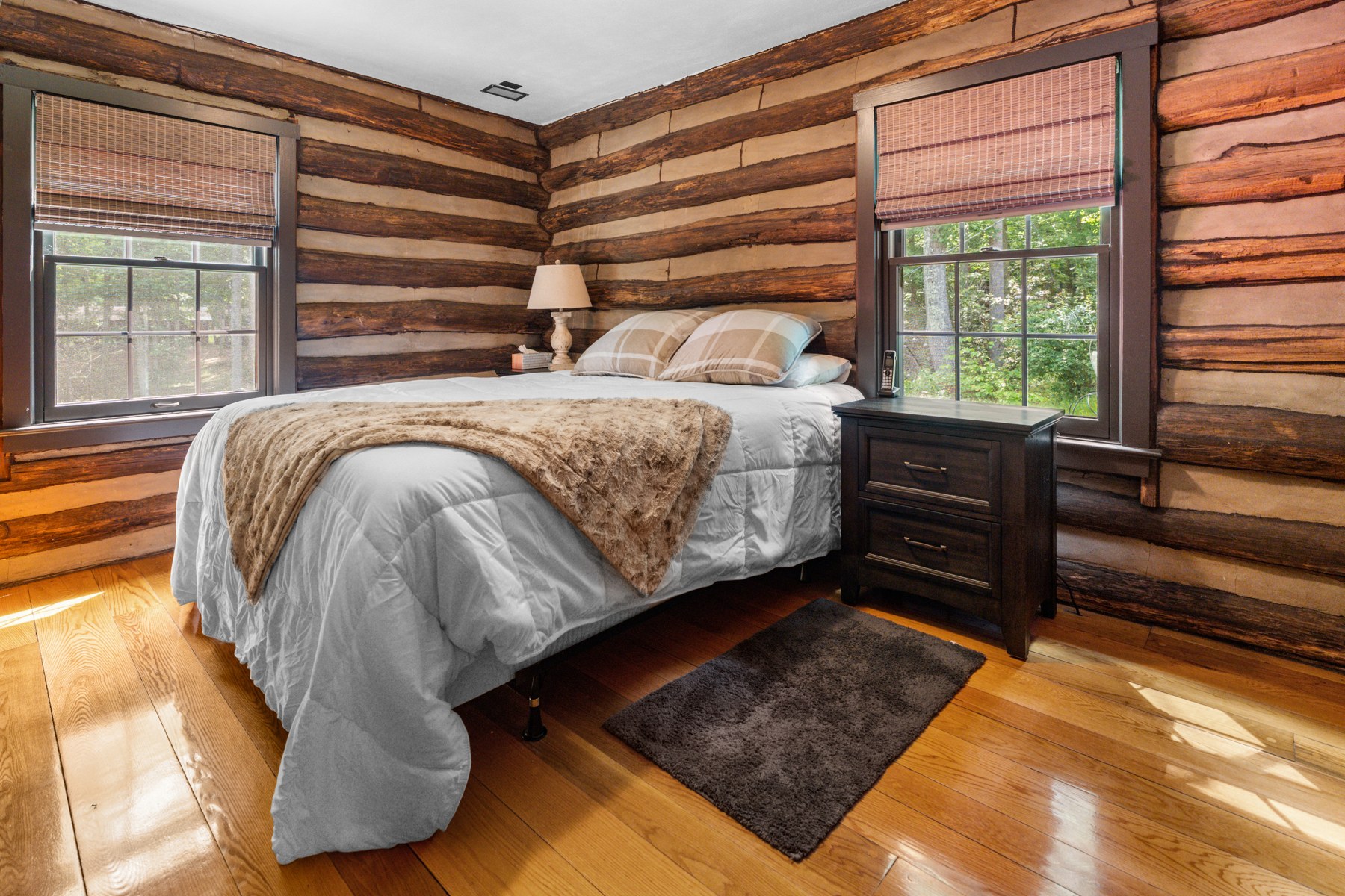 Lodge bedroom with timber walls and light from two windows
